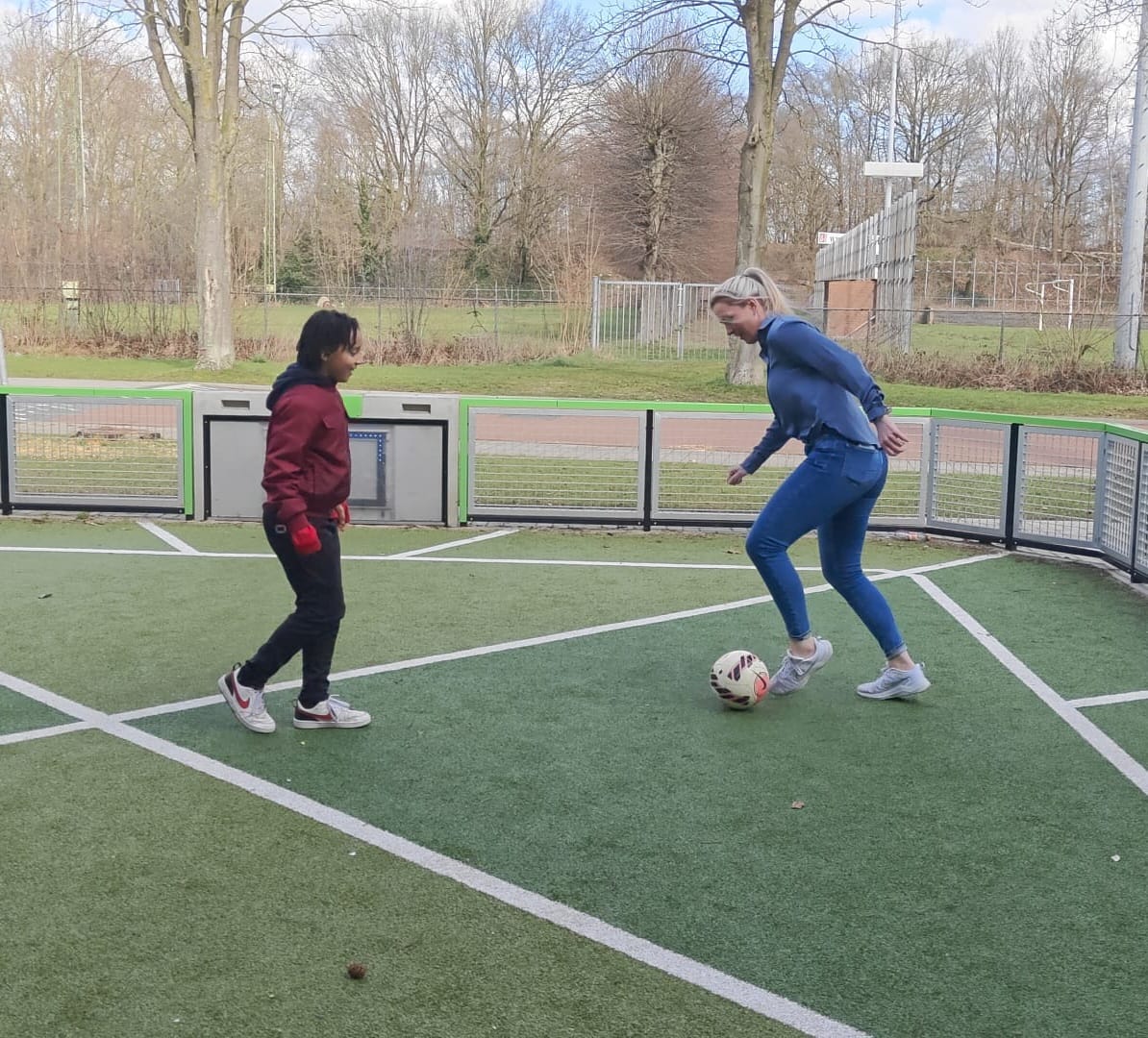 Moeder en zoon aan het voetballen
